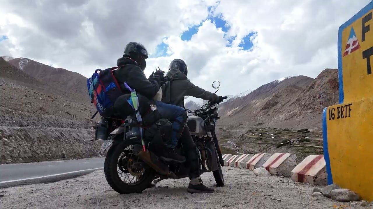 Two riders on a motorcycle on a mountain road in Ladakh